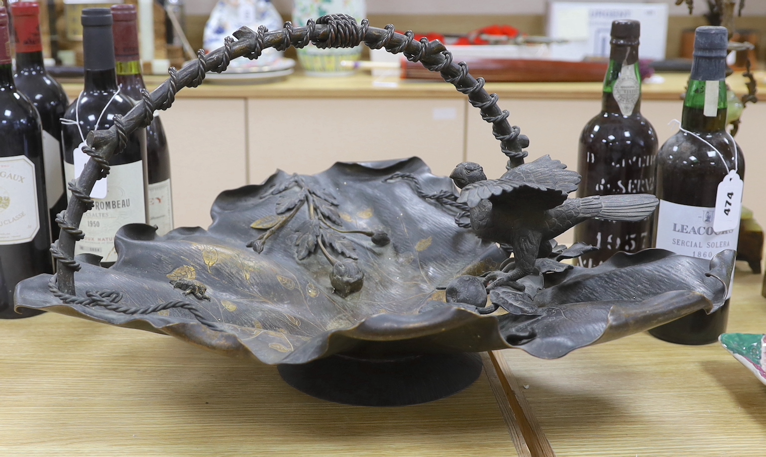 A Japanese bronze leaf centrepiece dish with a bird and flower surmount and handle, 53cm deep, 34cm high